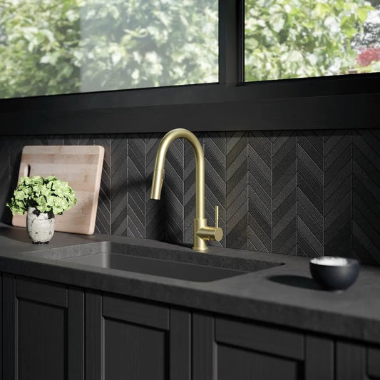 ZLINE Gemini Pull Down Single Handle Kitchen Faucet in Champagne Bronze (GEM-KF-CB) in a luxury kitchen with black countertops.