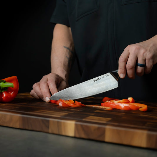 ZLINE Mark Estee 8 in. Professional Japanese Damascus Steel Chef Knife (KCKT-ME-JD) close-up, Mark Estee using the knife to cut peppers.