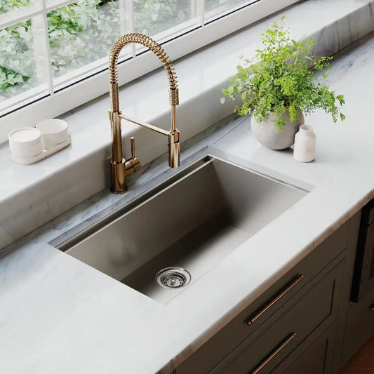 ZLINE Garmisch 30 in. Undermount Single Bowl Stainless Steel Kitchen Sink with Bottom Grid and Accessories (SLS-30) in a luxury kitchen with marble countertops and blue kitchen cabinets.