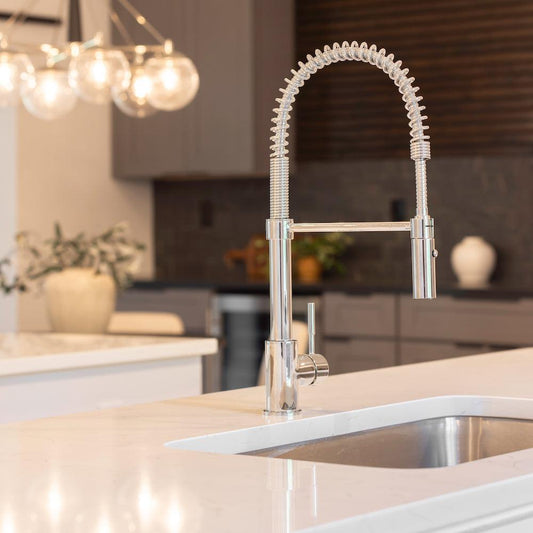 ZLINE Sierra Pull Down Spring Single Handle Kitchen Faucet in Chrome (SRA-KF-CH) in a rustic-style kitchen with white countertops.