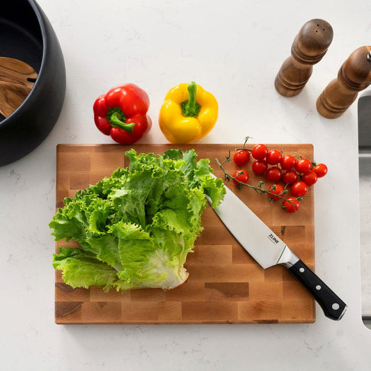 ZLINE 8 in. Professional German Steel Chef’s Knife (KCKT-GS) on a cutting board with fresh lettuce and cherry tomatoes, above.