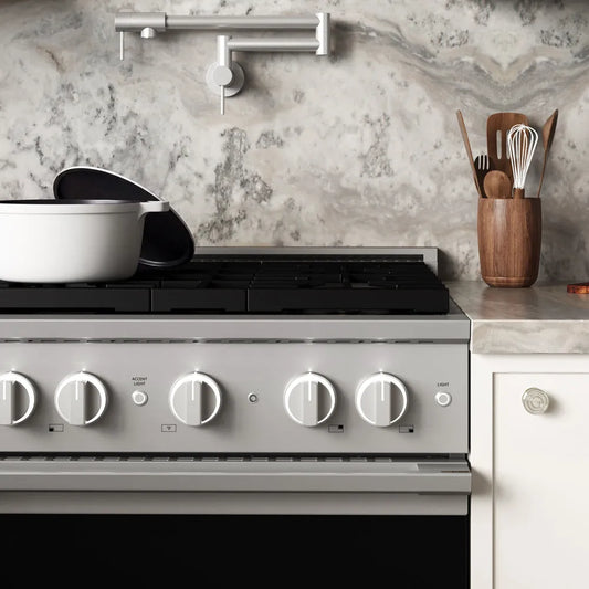 ZLINE 30 in. 4.2 cu. ft. Marino Dual Fuel Range with 4 Burner Gas Cooktop and Electric Convection Oven in Stainless Steel (MDR30) front close-up, set in a modern kitchen with marble countertops. A white pot sits on the cooktop, and a wooden utensil holder is on the counter.