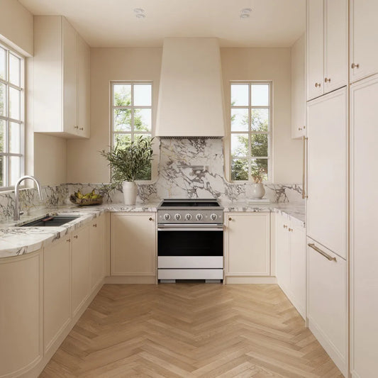 A modern kitchen interior with cream cabinetry, marble countertops and backsplash, light wood herringbone flooring, and a ZLINE 30 in. 4.2 cu. ft. Marino Induction Range with 4 Element Cooktop and Electric Convection Oven in Stainless Steel with White Matte Door (MINR-WM-30) at the center.