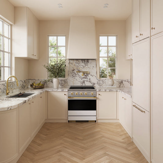 A modern kitchen interior with cream cabinetry, marble countertops and backsplash, light wood herringbone flooring, and a ZLINE Autograph Edition 30 in. 4.2 cu. ft. Marino Induction Range with 4 Element Cooktop and Electric Convection Oven in Stainless Steel with White Matte Door and Polished Gold Accents (MINRZ-WM-30-G).