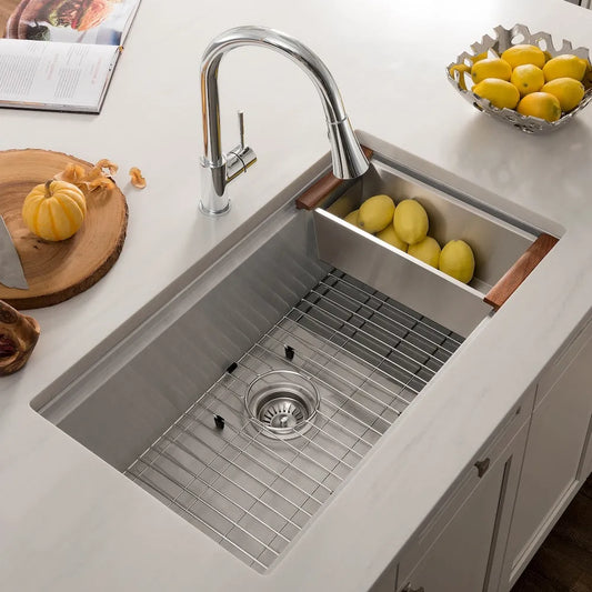 ZLINE 33 in. Garmisch Undermount Single Bowl Satin Stainless Steel Kitchen Sink with Bottom Grid and Accessories (SLS-33S) with lemons on a white countertop