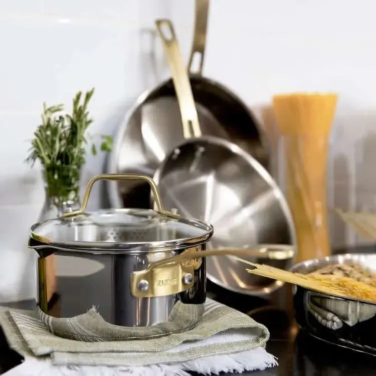 Stainless steel ZLINE cookware set featuring elegant gold-tone handles on a kitchen counter.