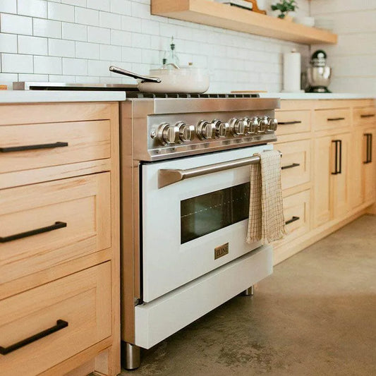 Stainless steel and white ZLINE professional range in a modern kitchen with light wood cabinets and a white tile backsplash.