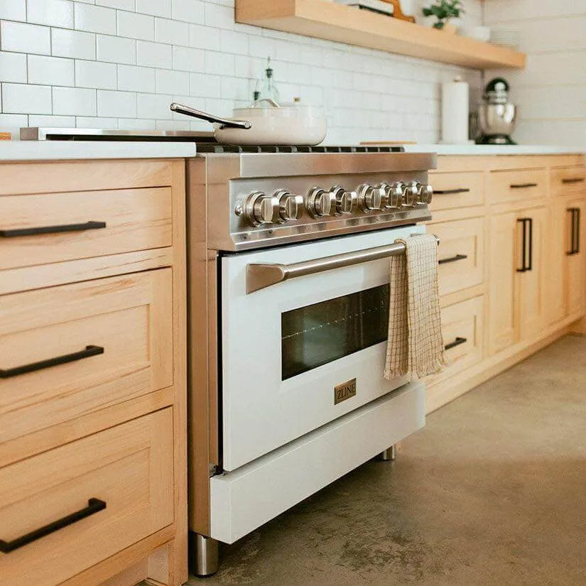 Stainless steel and white ZLINE professional range in a modern kitchen with light wood cabinets and a white tile backsplash.