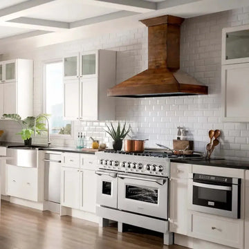 Stainless steel ZLINE range and rustic wooden hood in a bright white kitchen with subway tile backsplash.