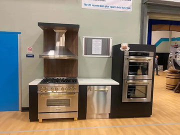 ZLINE stainless steel kitchen appliances with gold accents displayed at a Boys and Girls Club fundraiser event.
