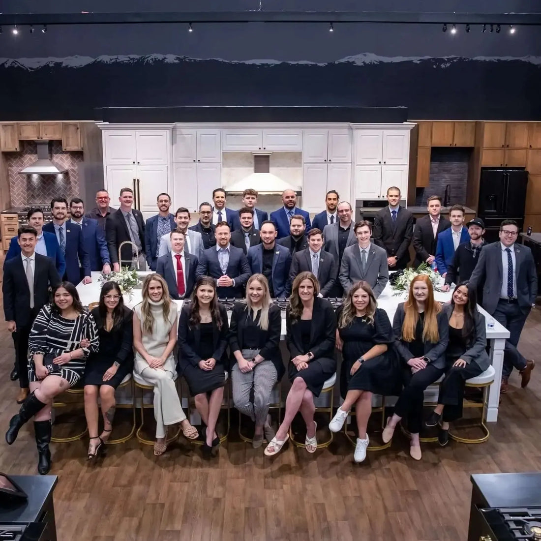 ZLINE team members in professional attire posing in a modern kitchen showroom.