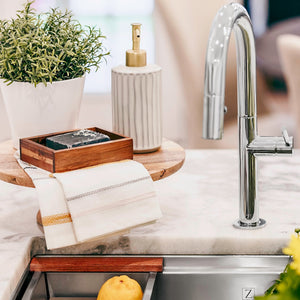ZLINE Voltaire Pull Down Single Handle Kitchen Faucet in Chrome (VLT-KF-CH) above a kitchen sink with lemons and decorative items on a marble countertop.