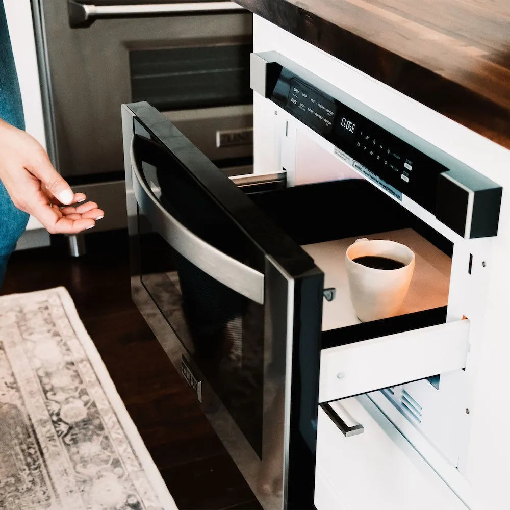 Person opening a ZLINE 24 in. 1.2 cu. ft. Built-in Microwave Drawer in Stainless Steel (MWD-1) with a cup of coffee inside.