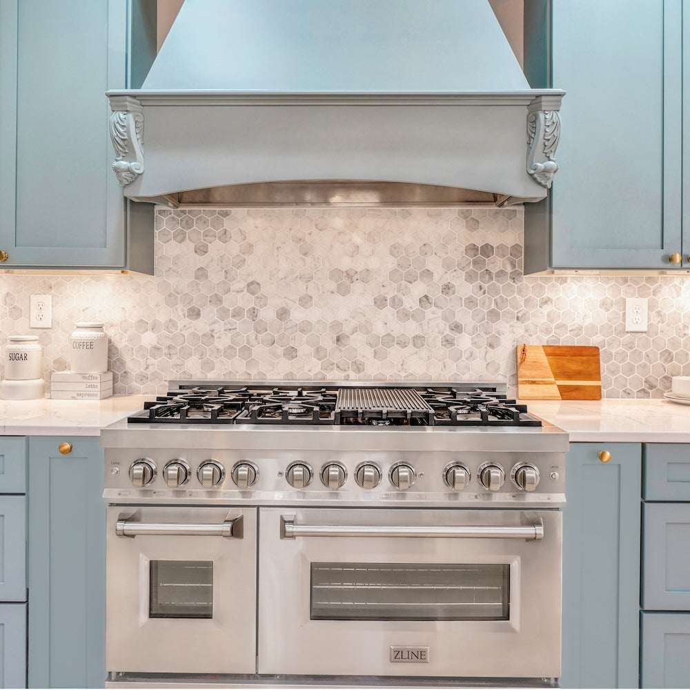 ZLINE 48 in. 6.0 cu. ft. Legacy Dual Fuel Range with 7 Burner Gas Cooktop and 2 Electric Ovens in Stainless Steel (RA48) in a kitchen with light blue cabinets and a tiled backsplash.