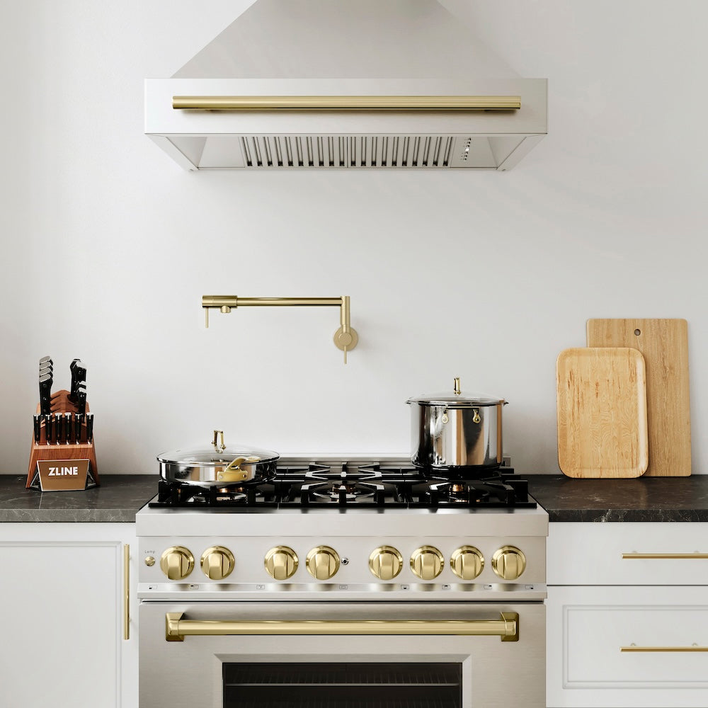 ZLINE Gemini Pot Filler in Champagne Bronze (GEM-FPF-CB) above a stainless steel range with bronze accents in a modern kitchen setting, front.