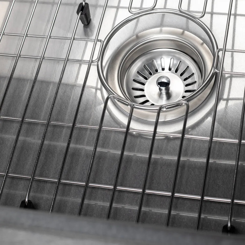 Metal sink strainer inside a ZLINE 30 in. Zermatt Farmhouse Apron Mount Single Bowl Satin Stainless Steel Kitchen Sink with Bottom Grid (SAS-30S)