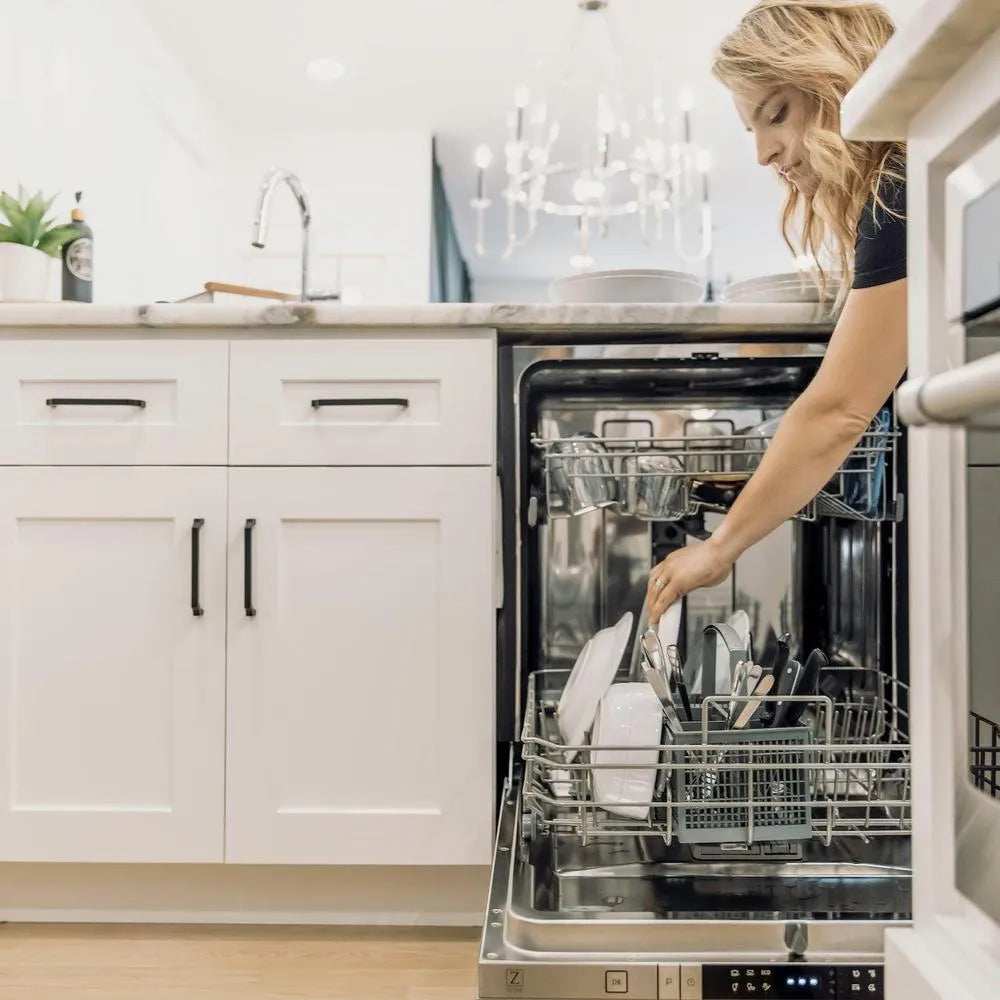Woman opening a ZLINE 24 in. Top Control Built-In Dishwasher with Satin Stainless Steel Panel and Stainless Steel Tub with Modern Style Handle, 52dBa (DW-SN-24) in a designer kitchen