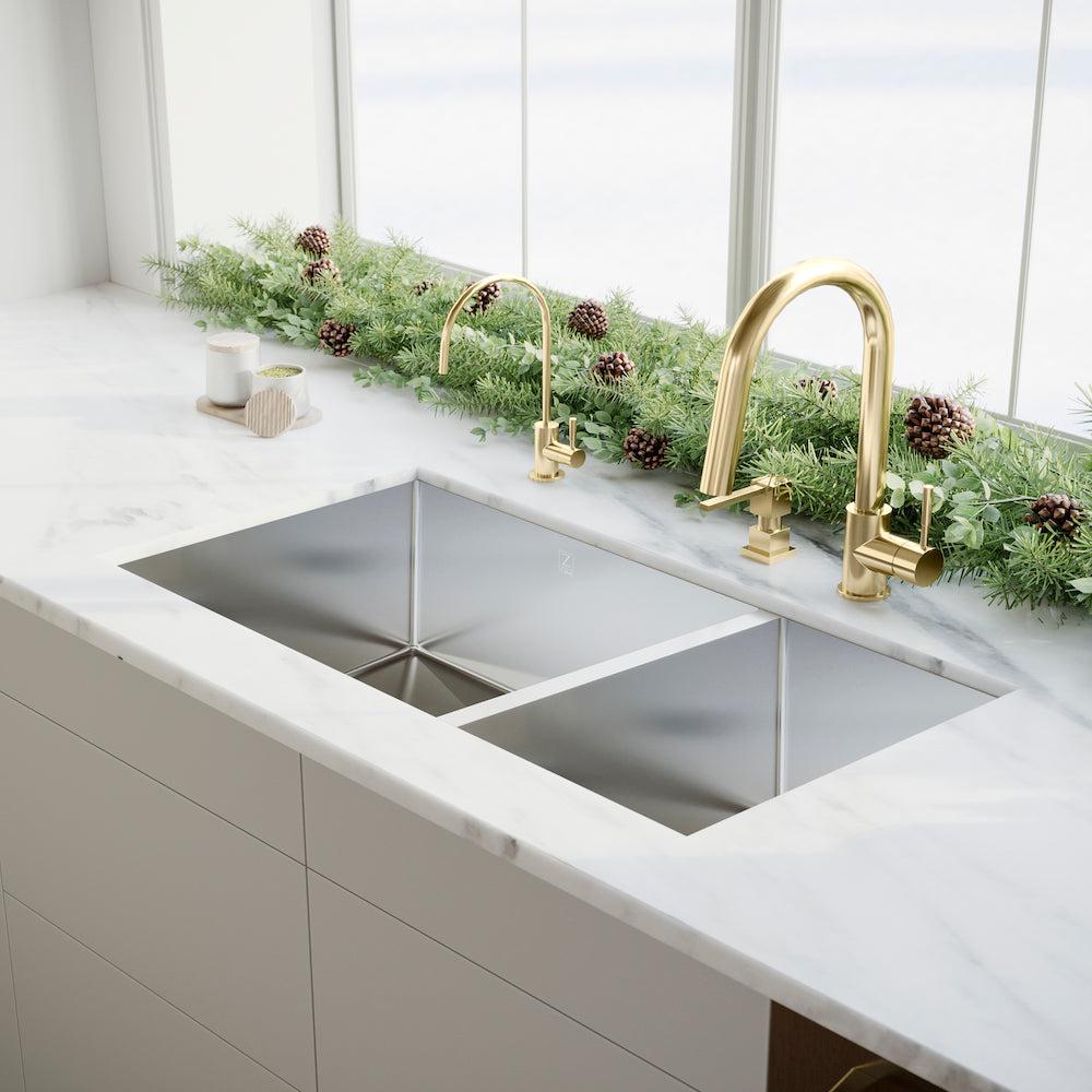 ZLINE Gemini Pull Down Kitchen Faucet in Polished Gold (GEM-KF-PG) in a modern mountain-style kitchen with matching drink faucet, close-up, side.