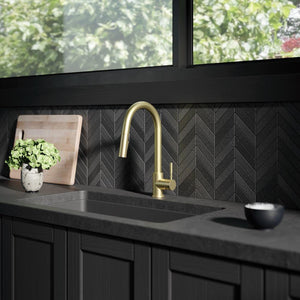 ZLINE Gemini Pull Down Single Handle Kitchen Faucet in Champagne Bronze (GEM-KF-CB) in a luxury kitchen with black countertops.