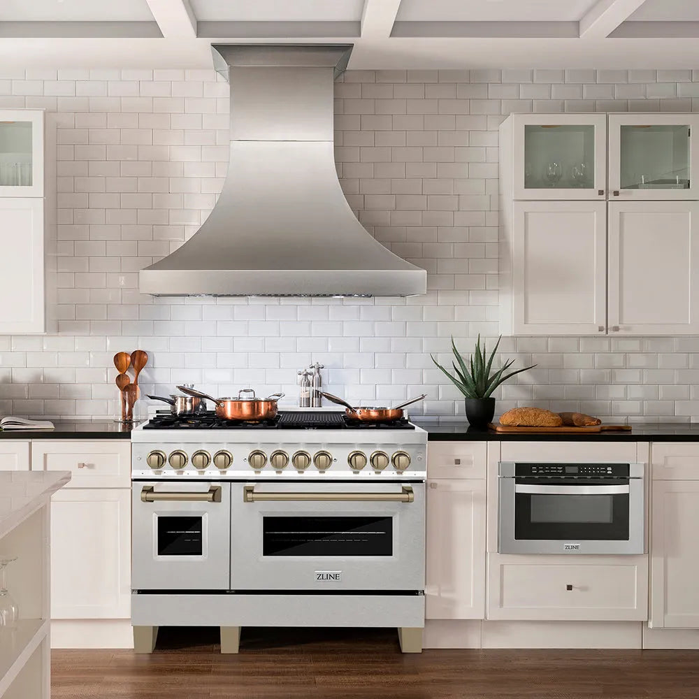 Modern farmhouse kitchen with a ZLINE Autograph Edition 48 in. 6.0 cu. ft. Legacy Dual Fuel Range with 7 Burner Gas Cooktop and 2 Electric Ovens in Satin Stainless Steel and Champagne Bronze Accents (RASZ-SN-48-CB) and oven, white cabinets, and black countertops.
