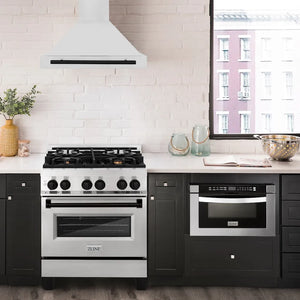 Modern kitchen with a range, ZLINE Autograph Edition 30 in. Convertible Stainless Steel Range Hood with Stainless Steel Shell and Matte Black Accents (KB4STZ-30-MB), and a microwave oven against a white brick wall.
