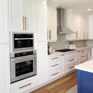 Modern kitchen with white cabinets, ZLINE 24 in. 1.6 cu. ft. Built-in Convection Microwave Oven in Stainless Steel with Speed and Sensor Cooking (MWO-24), and a blue island.