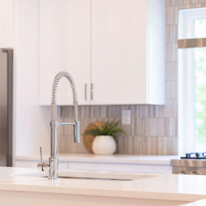 ZLINE Sierra Pull Down Spring Single Handle Kitchen Faucet in Chrome (SRA-KF-CH) in a cottage-style kitchen, from behind.