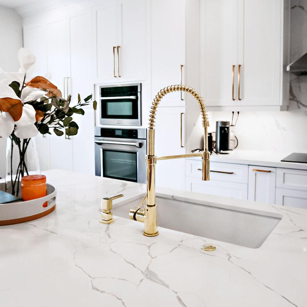 ZLINE Sierra Pull Down Spring Kitchen Faucet in Polished Gold (SRA-KF-PG) in an immaculate white kitchen, behind.