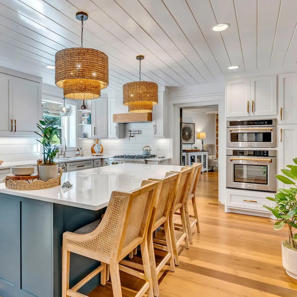 Custom kitchen with ZLINE Autograph Edition 30 in. Professional True Convection Single Wall Oven with Air Fry and Self Clean in Stainless Steel with Polished Gold Handle (WASZ-30-G), white island, wooden chairs, and stainless steel appliances.