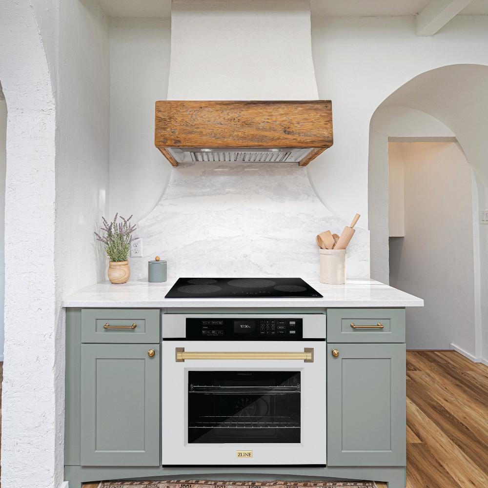 ZLINE Autograph Edition 30 in. Professional True Convection Single Wall Oven with Air Fry and Self Clean in Stainless Steel with White Matte Door and Champagne Bronze Handle (WASZ-WM-30-CB) lifestyle in a rustic kitchen below induction cooktop with custom range hood.