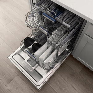 Open ZLINE Autograph Edition 24 in. Tallac Series 3rd Rack Dishwasher with Auto Door Open Drying, 51dBa, Stainless Steel Panel with Matte Black Handle (DWVZ-304-24-MB) with silverware and dishes inside on a wooden floor.