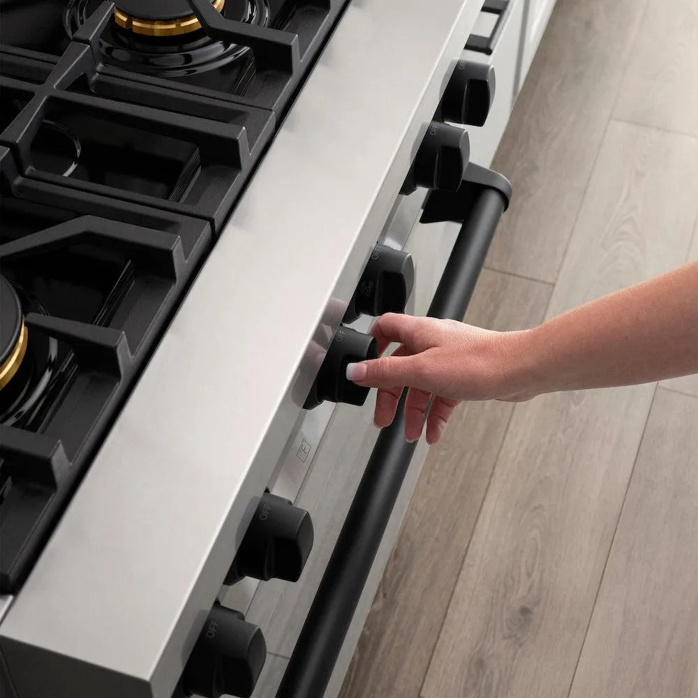 ZLINE Autograph Edition 30 in. 4.0 cu. ft. Legacy Dual Fuel Range with 4 Burner Gas Cooktop and Electric Convection Oven in Stainless Steel and Matte Black Accents (RAZ-30-MB) close-up, a woman's hand adjusting cooktop knob from above.