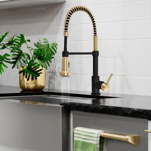 ZLINE Autograph Edition Apollo Pull Down Spring Single Handle Kitchen Faucet in Matte Black and Champagne Bronze (APL-KF-ZMBCB) in a luxury kitchen, spray mode on.