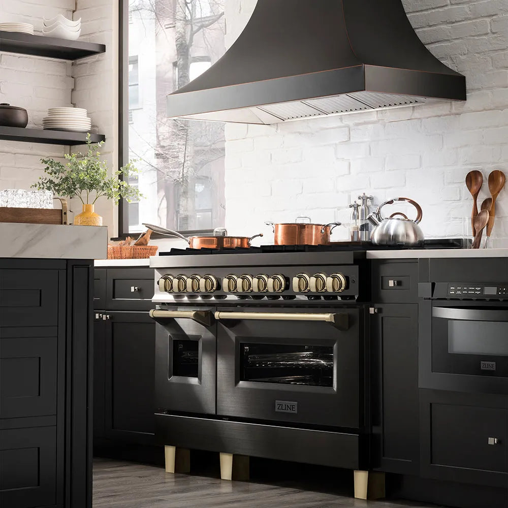 Modern kitchen with ZLINE Autograph Edition 48 in. 6.0 cu. ft. Legacy Dual Fuel Range with 7 Burner Gas Cooktop and 2 Electric Ovens in Black Stainless Steel and Polished Gold Accents (RABZ-48-G) and hood, white tiled walls, and wooden utensils.