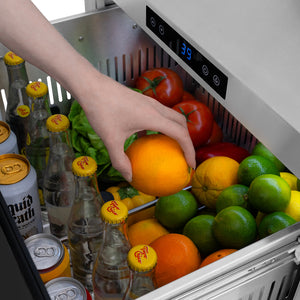 ZLINE Autograph Edition 24 in. Touchstone 168 Can Outdoor-Rated Dual Refrigerator Drawer with Black Stainless Steel Doors and Champagne Bronze Handles (RDSOZ-BS-24-CB) close-up detail, reaching for an orange in top drawer.