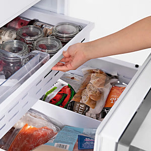 ZLINE Autograph Edition 60 in. 32.2 cu. ft. French Door Built-In Bottom Freezer Refrigerator with Water Dispenser and Ice Maker in Stainless Steel with Polished Gold Accents (RBIVZ-304-60-G) hand reaching into bottom freezer drawer filled with various food items.