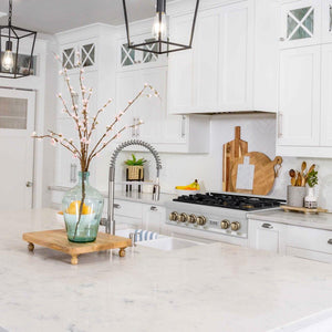 ZLINE Autograph Edition 36 in. Legacy Gas Rangetop with 6 Burners and Porcelain Cooktop in Stainless Steel with Champagne Bronze Accents (RTZ-36-CB) in a kitchen with white cabinets, marble countertops, and decorative elements.