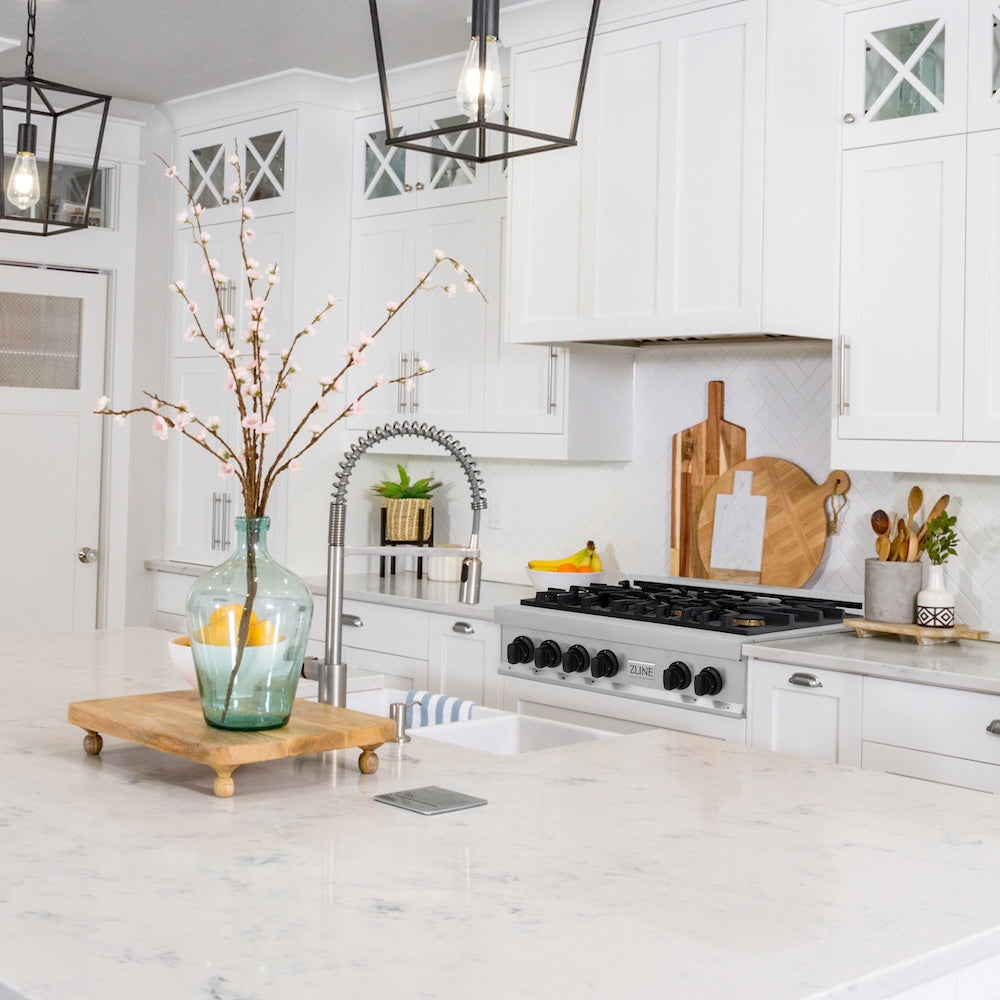 ZLINE Autograph Edition 36 in. Legacy Gas Rangetop with 6 Burners and Porcelain Cooktop in Stainless Steel with Matte Black Accents (RTZ-36-MB) in a farmhouse kitchen with white cabinets, marble countertops, and decorative elements.