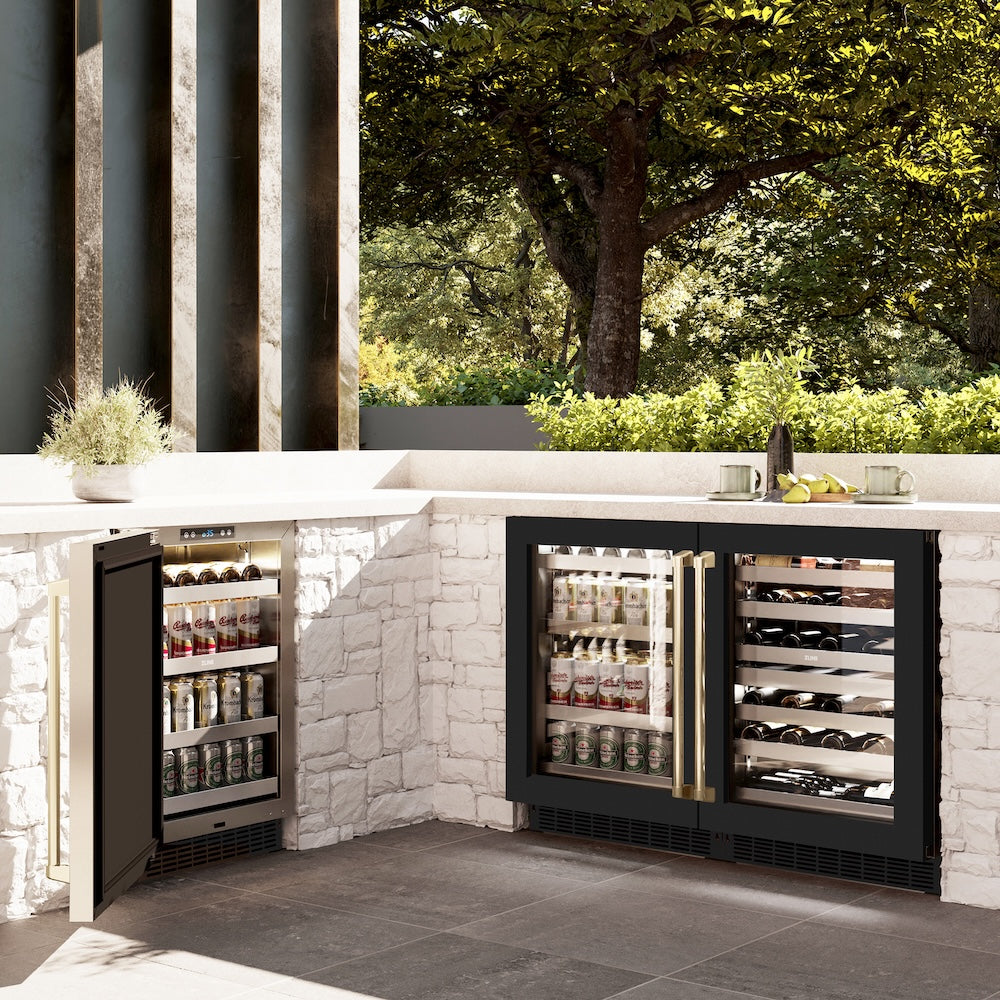 ZLINE Autograph Edition 24 in. Touchstone Dual Zone 44 Bottle Wine Cooler With Black Matte Glass Door And Champagne Bronze Handle (RWDOZ-BLM-24-CB) side, in an outdoor kitchen with two matching beverage fridges displaying drinks and bottles.