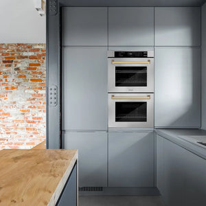 Modern kitchen with ZLINE Autograph Edition 30 in. Professional True Convection Double Wall Oven with Air Fry and Self Clean in Stainless Steel with Champagne Bronze Handles (WADZ-30-CB) and a brick wall.