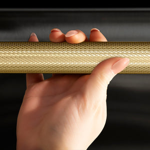 ZLINE Autograph Edition 24 in. Monument Series 3rd Rack Top Touch Control Tall Tub Dishwasher in Black Stainless Steel with Champagne Bronze Helix Handle, 45dBa (DWMTZ-BS-24-KCB) hand holding Helix handle showing knurled diamond texture.