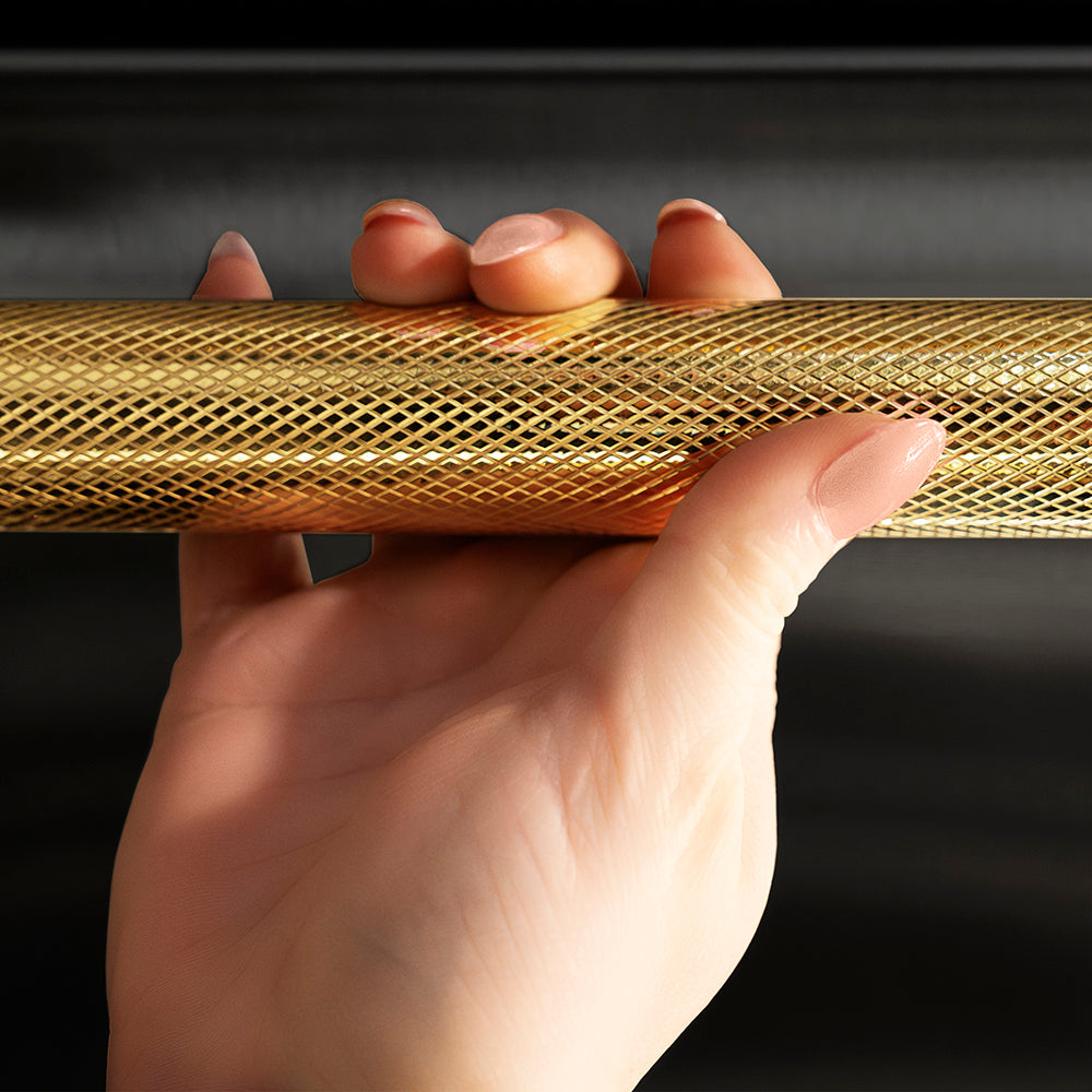 ZLINE Autograph Edition 24 in. Monument Series 3rd Rack Top Touch Control Tall Tub Dishwasher in Black Stainless Steel with Polished Gold Helix Handle, 45dBa (DWMTZ-BS-24-KG) hand holding Helix handle showing knurled diamond texture.