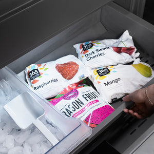 ZLINE Autograph Edition 60 in. 32.2 cu. ft. French Door Built-In Bottom Freezer Refrigerator with Water Dispenser and Ice Maker in Black Stainless Steel with Graphite Gray Interior and Polished Gold Helix Handles (GRBIVZ-BS60KG) frozen fruit packages including raspberries, cherries, and mangoes in bottom freezer drawer.