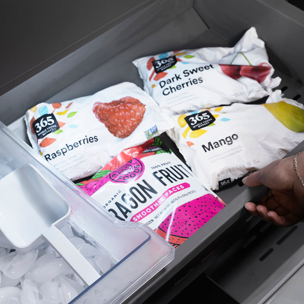 ZLINE Autograph Edition 36 in. 19.6 cu. ft. French Door Built-In Bottom Freezer Refrigerator with Water Dispenser and Ice Maker in Black Stainless Steel with Stainless Steel Interior and Polished Gold Helix Handles (SRBIVZ-BS36KG) frozen fruit packages including raspberries, cherries, and mangoes in bottom freezer drawer.