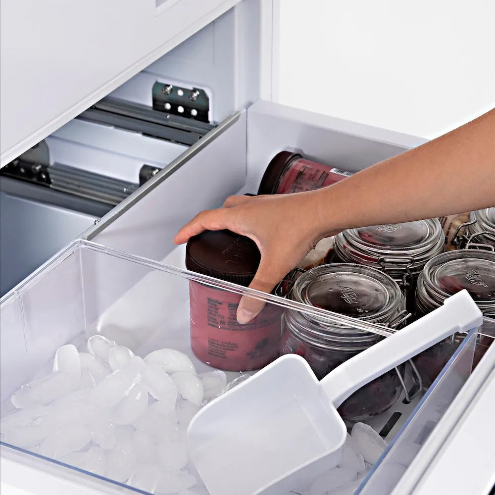 ZLINE 30 in. 16.1 cu. ft. Panel Ready Built-In Bottom Freezer Refrigerator with Water Dispenser and Ice Maker (RBIV-30) hand reaching into freezer drawer filled with containers and ice cubes.