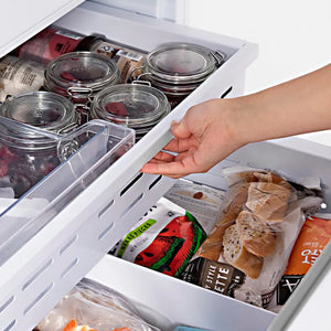 ZLINE 60 in. 32.2 cu. ft. Panel Ready French Door Built-In Bottom Freezer Refrigerator with Water Dispensers and Ice Makers (RBIV-60) hand reaching into bottom freezer drawer filled with various food items.