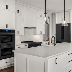 Modern farmhouse kitchen with white cabinets, ZLINE 36 in. 22.5 cu. ft. Counter-Depth French Door Refrigerator with Ice Maker in Fingerprint-Resistant Black Stainless Steel (RFM-36-BS), and marble countertops.