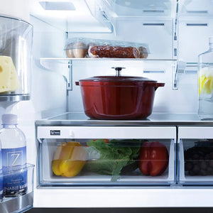 ZLINE Autograph Edition 36 in. 21.6 cu. ft. Counter-Depth French Door Refrigerator with Water and Ice Dispenser in Fingerprint-Resistant Black Stainless Steel with Champagne Bronze Helix Handles (RFMZ-W36-BS-KCB) open with a red pot, vegetables, and a water bottle inside.