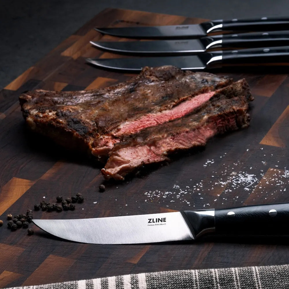 ZLINE 6-Piece Professional German Steel Steak Knife Set (STK-GS-6) on a cutting board with steak.