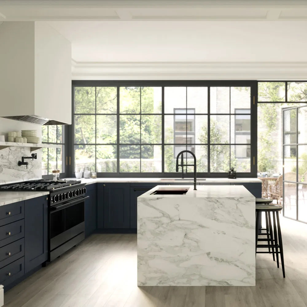 ZLINE 48 in. 6.7 cu. ft. Marino Double Oven Gas Range with 8 Burner Cooktop in Black Stainless Steel (MGRB-48) side, in a modern kitchen interior with dark navy cabinetry, a white marble island, black faucets, and large black-framed windows overlooking greenery.